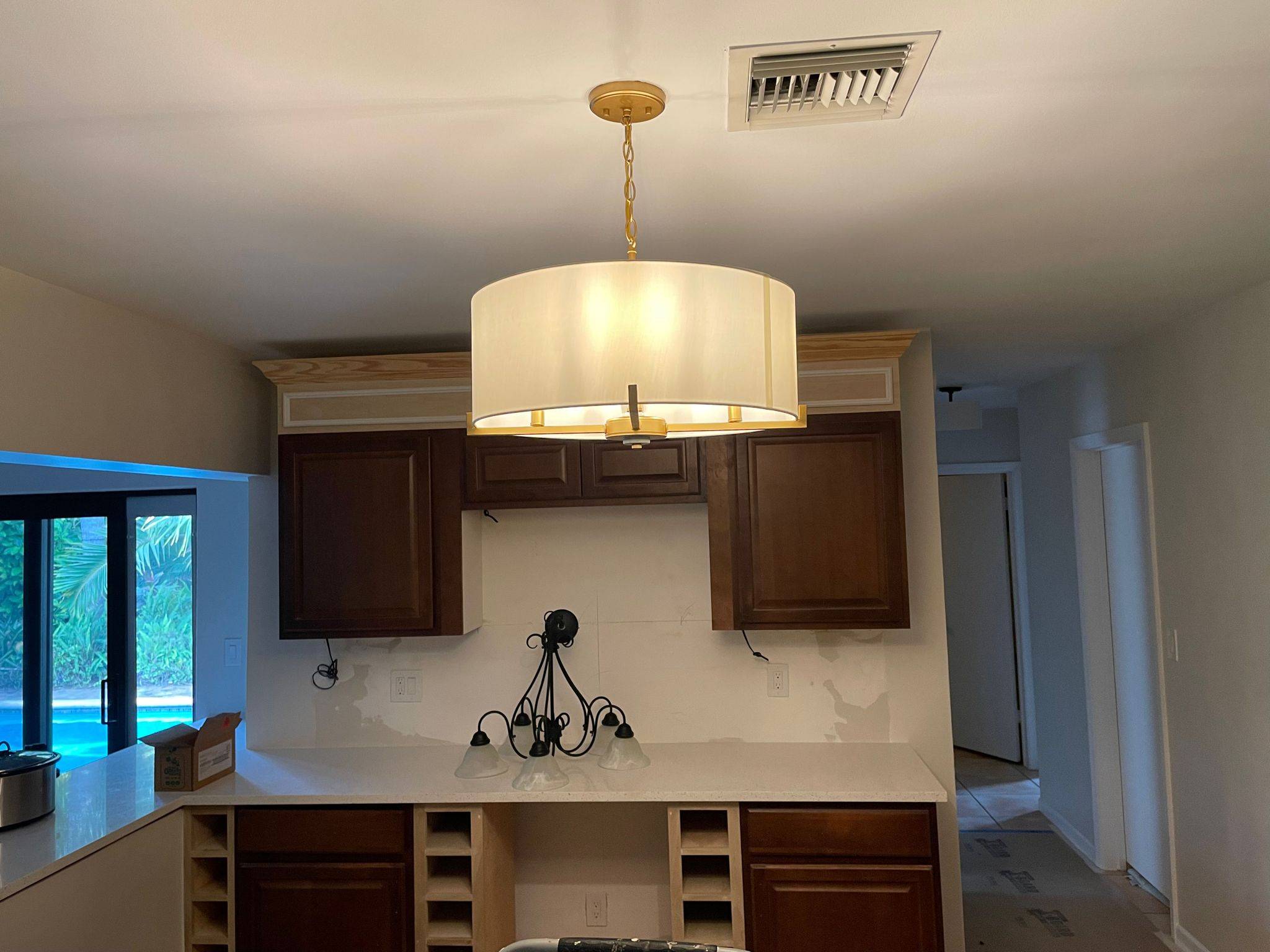 Kitchen chandelier install overlooking the pool